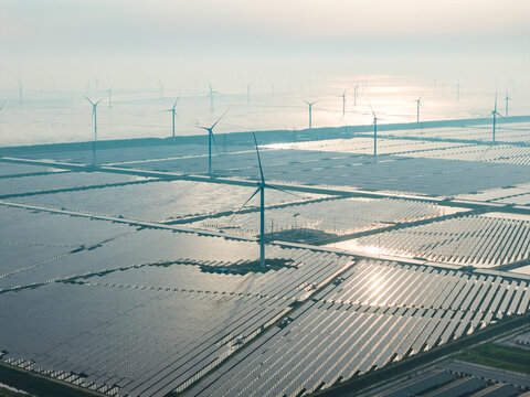  floating solar farm and wind turbines at sunset over water