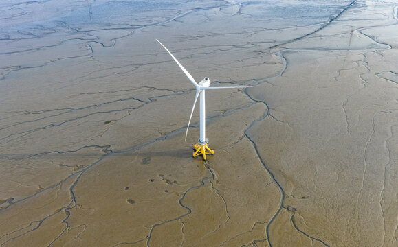 offshore wind turbine standing on tidal mudflat at low tide