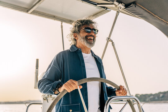 Smiling man steering sailboat enjoying freedom and adventure