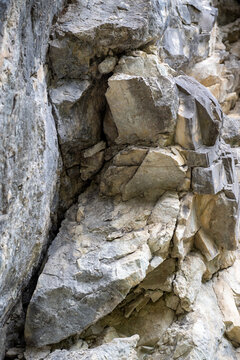 Paroi rocheuse escarp&eacute;e en calcaire stri&eacute; avec v&eacute;g&eacute;tation alpine &agrave; la base, g&eacute;ologie et texture de roche naturelle.