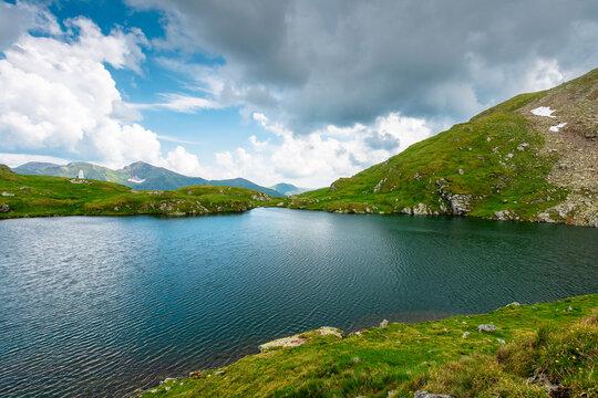 lake in romania mountain landscape. clear source of water. outdoor adventures in summer. cloudy sky over the fagaras ridge