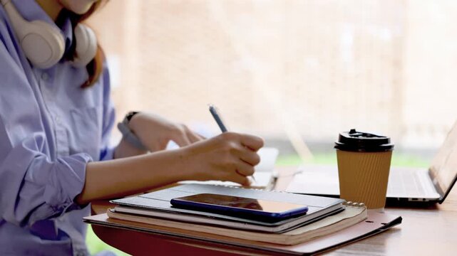 Young Asian Businesswoman Working Remotely with Laptop and Smartphone in Traditional Wooden Cafe, Digital Nomad Lifestyle
