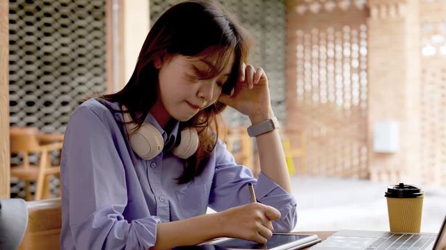 Young Asian Businesswoman Working Remotely with Laptop and Smartphone in Traditional Wooden Cafe, Digital Nomad Lifestyle