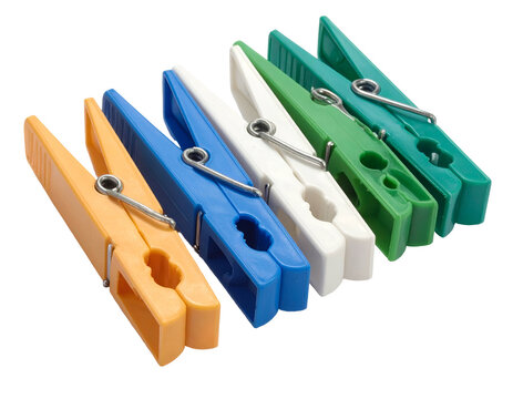 Row of colorful plastic clothes pegs isolated on a black background