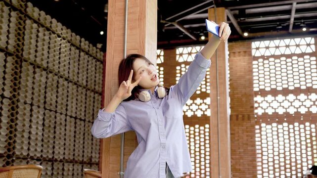 Young Asian Businesswoman Working Remotely with Laptop and Smartphone in Traditional Wooden Cafe, Digital Nomad Lifestyle