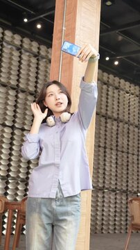 Young Asian Businesswoman Working Remotely with Laptop and Smartphone in Traditional Wooden Cafe, Digital Nomad Lifestyle