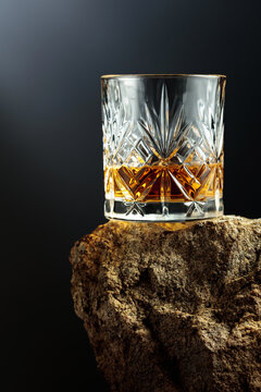 Glass of whiskey on a rough granite.