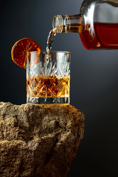 Whiskey is poured from a bottle into a glass.