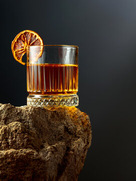 Old-fashioned cocktail with dried orange slice.