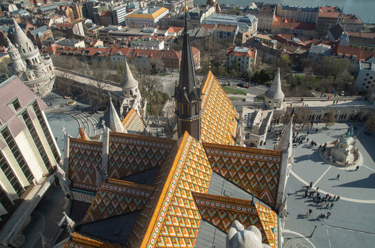 Top-down view of Matthias Church colorful Zsolnay roof tiles and Holy Trinity Square from Matthias Church spire in Budapest, Hungary
