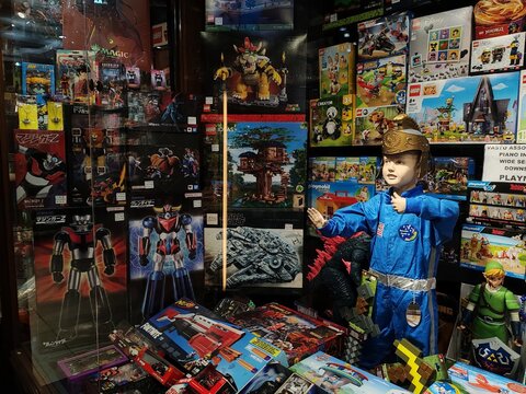 Rome, Italy - July 15, 2025, detail of the window of a collectible toy shop with various very famous characters for sale in the city center.