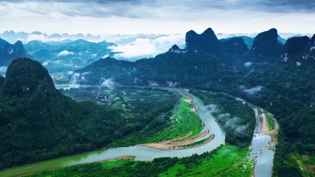 Li River winding through dramatic karst mountain peaks in mist, Guilin, Guangxi, China. Ideal for travel and landscape concepts.