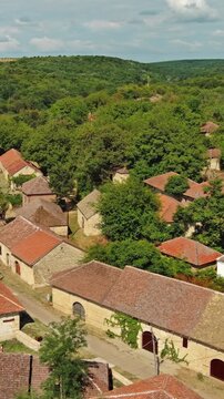 Aerial around view of old rustic vintage houses with wine cellars in Rogljevacke pivnice in Negotin region of Serbia. Vertical video 4k