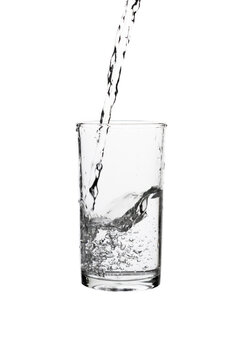 Pouring fresh drinking water into a clear glass isolated on a white background. Hydration, purity, refreshment, and healthy lifestyle concept.