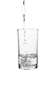 Pouring fresh drinking water into a clear glass isolated on a white background. Hydration, purity, refreshment, and healthy lifestyle concept.