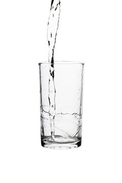 Pouring fresh drinking water into a clear glass isolated on a white background. Hydration, purity, refreshment, and healthy lifestyle concept.