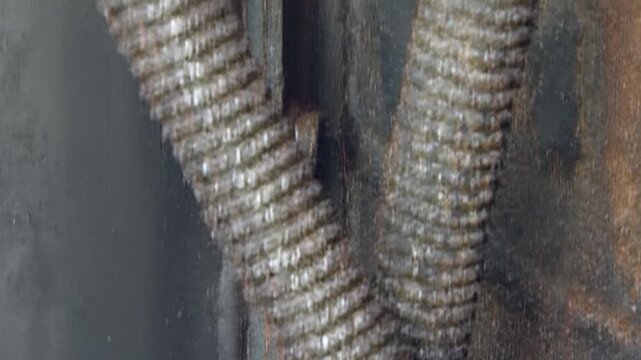 A detailed perspective on a weathered air filtration unit. Discover the intricate build-up of industrial rust, dark grime, and metallic wear on essential engine components and flexible conduits.