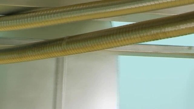 Witness vital operation of advanced air purification system. Golden conduits funnel air into sleek industrial filter, ensuring pristine atmospheric quality within bright factory setting during day.