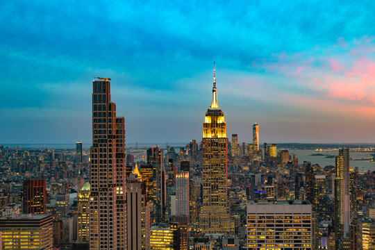 Stunning panoramic view of the Manhattan skyline in New York during dusk, featuring illuminated skyscrapers against a vibrant twilight sky.