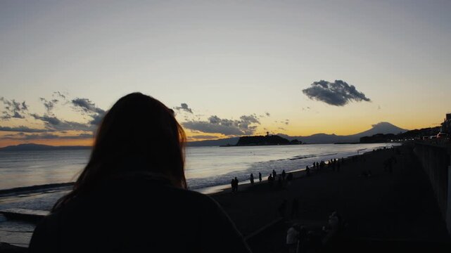 Woman watching sunset over mount fuji and enoshima island