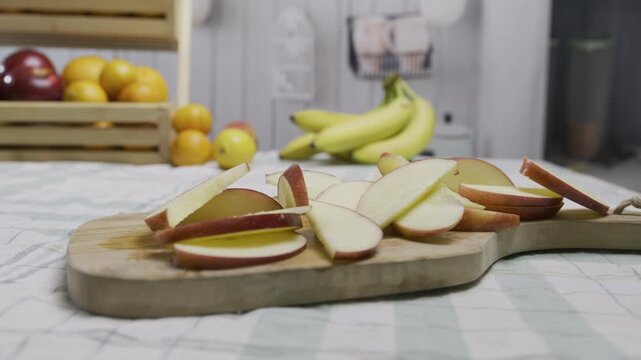 Cluster of apple slices on cutting board in beautiful kitchen - tracking closeup shot