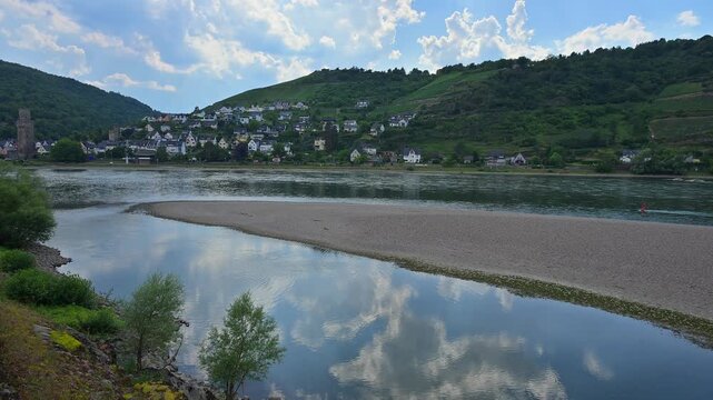 Ein ruhiges Dorf erstreckt sich &uuml;ber H&uuml;gel am Ufer eines Flusses mit einer Sandbank, unter einem bew&ouml;lkten Himmel, Bacharach am Rhein, Rhein, Rheingau, Hessen, Deutschland
Ein ruhiges Dorf erstreckt s