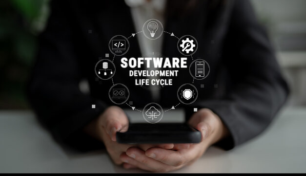 Hands Holding Smartphone with Icons Representing Software Development Life Cycle in Modern Office Setting Quark.