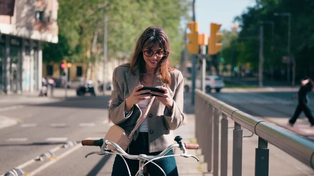 Video of beauty woman taking a selfie while riding a bicycle in the bike lane through the city.