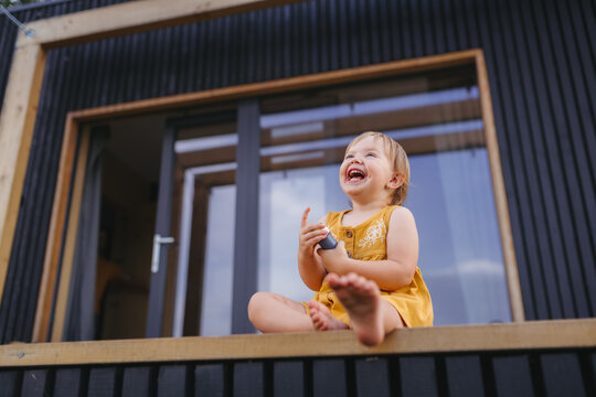 Small child playing outdoors, weekend away in container house in countryside.