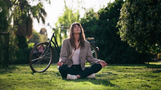 Video of pretty woman doing ioga while resting after cycling in the park.