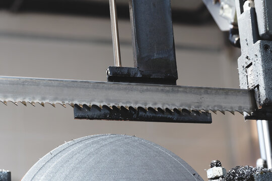 Thin, round metal discs cut with abandsaw, with metal shavings and lubricant on them. tech industrial technology background