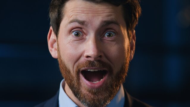 Close up shocked amazed Caucasian middle-aged business man looking at camera open mouth with shock at night evening office surprised wonder businessman male professional look stunned with good news