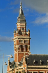 Fototapeta premium Dunkirk Town Hall., It’s the city’s emblematic neo‑Flemish landmark, known for its tall clock tower, red brick façade, and ornate carved detailing.