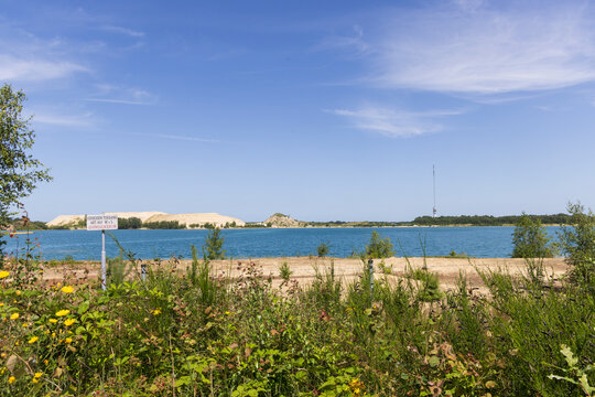 Lake Achterste Plas for sand extraction in Hoogersmilde in Drenthe,  Netherlands with danger sign,  blue water and sandy shore