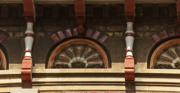 Decorative tiles and patterned brickwork form a detailed Dunkirk fa&ccedil;ade, where color and craft stand out in the sunlight.
