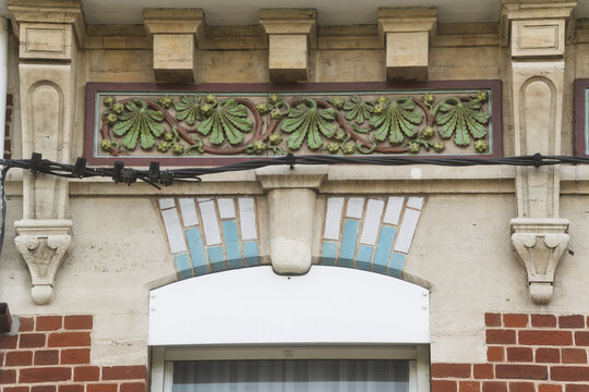 Decorative tiles and patterned brickwork form a detailed Dunkirk fa&ccedil;ade, where color and craft stand out in the sunlight.
