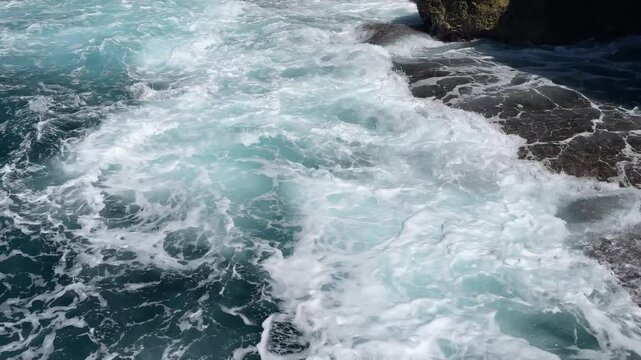 Sea waves crashing against a rocky shore, seen from above. Indonesia, Lombok Island.