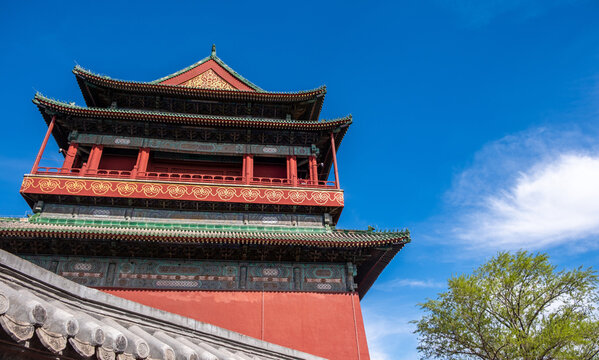 Historic red Chinese tower and tiled roof under blue spring sky in Beijing China