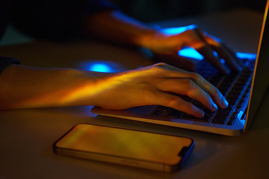 Neon cyberspace coding on laptop with smartphone nearby