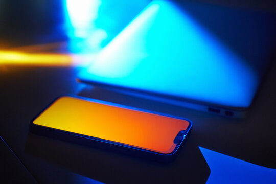 Neon smartphone and laptop glow in futuristic cyberspace