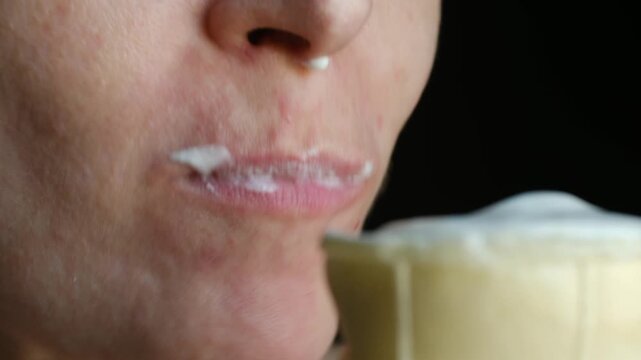 Intimate close up young woman face enjoys eating vanilla ice cream in wafer cone against black background, with sweet treat melting, smudging lips. Close up woman eating ice cream cone with pleasure