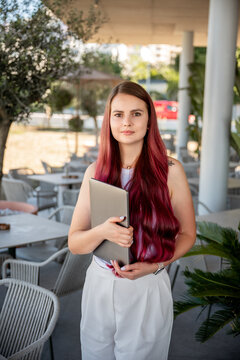 Young professional woman holding laptop at outdoor cafe