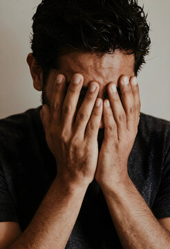 Man covering face with hands, expressing stress, anxiety, and emotional distress, mental health