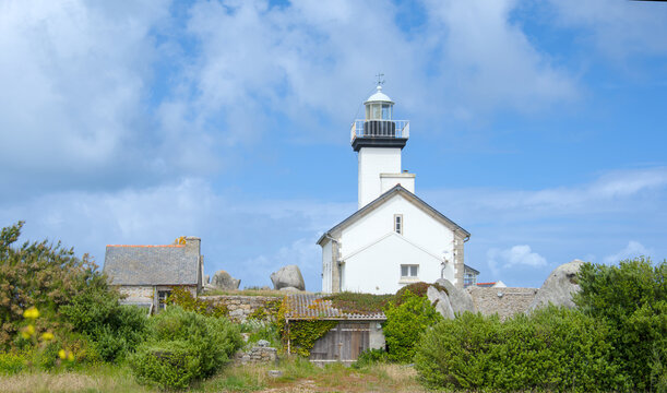 Phare de Pontusval lighthouse surrounded by granite rocks on the sandy coast of Brittany 