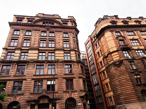 Historic redbrick commercial buildings in Manchester, UK with ornate Victorian architecture and detailed urban facades