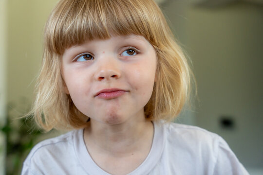 Curious Little Girl Making Funny Face Portrait Showing Childhood Personality And Emotions