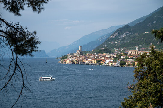 Scenic Lake Garda landscape with boat, village and mountain