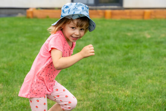 Happy Little Girl Running In Garden During Summer Outdoor Play And Active Childhood