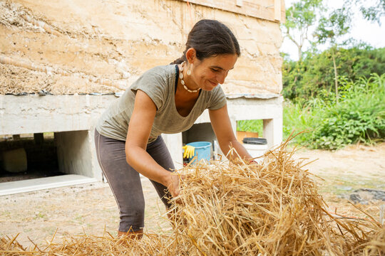 Woman carrying straw for bahareque house construction