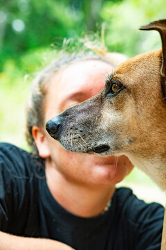 Close-up of dog profile with owner in soft outdoor bokeh